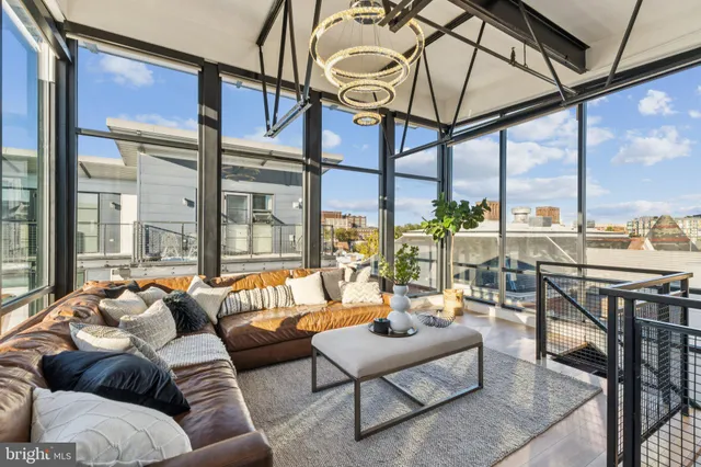 a living room with furniture city view and large windows