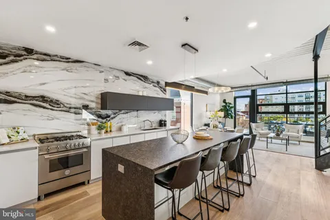 a kitchen with a table chairs stove and wooden floor