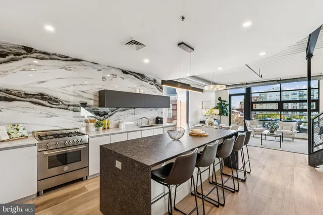 a kitchen with a table chairs stove and wooden floor
