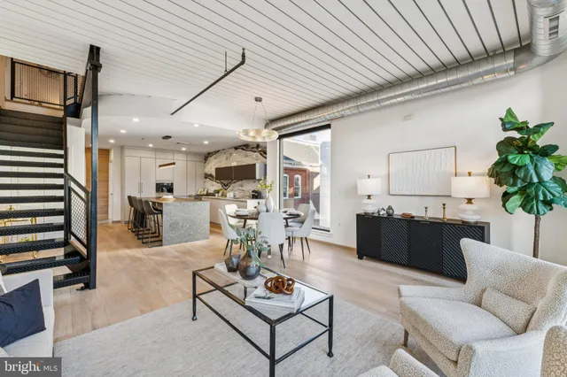 a living room with furniture kitchen view and a table