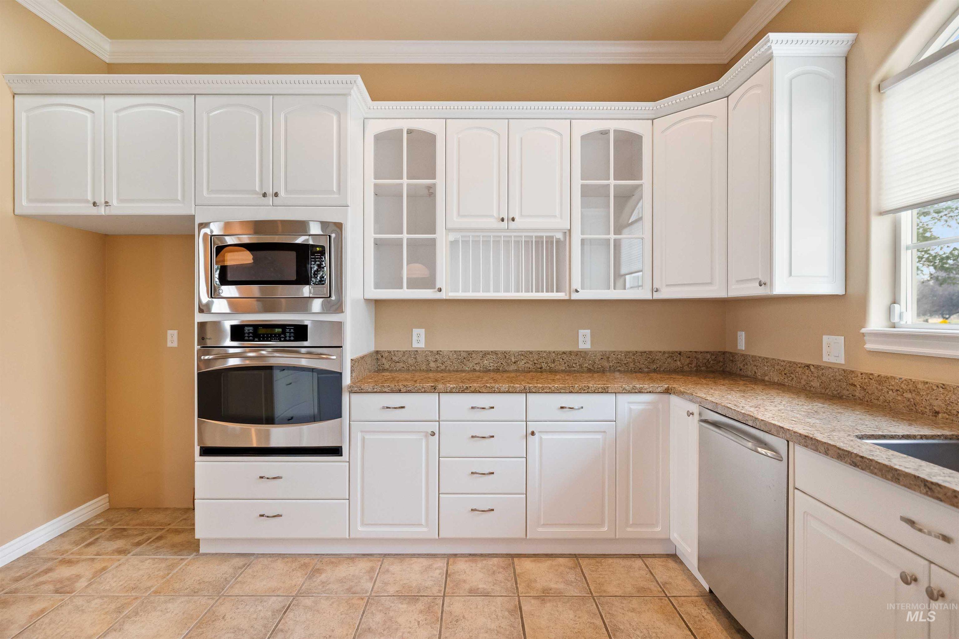 3404 Ridge Line Drive Kimberly, ID 83341 - Photo 11 of 50 Kitchen featuring white cabinetry, built-in stainless steel microwave and oven, granite-finish countertops, and tile flooring