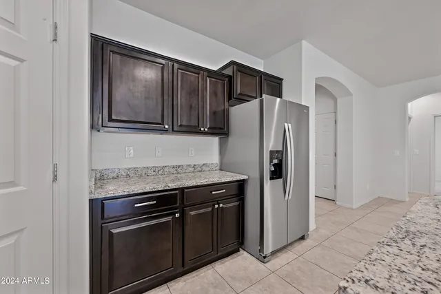 a kitchen with stainless steel appliances granite countertop a refrigerator and a stove top oven