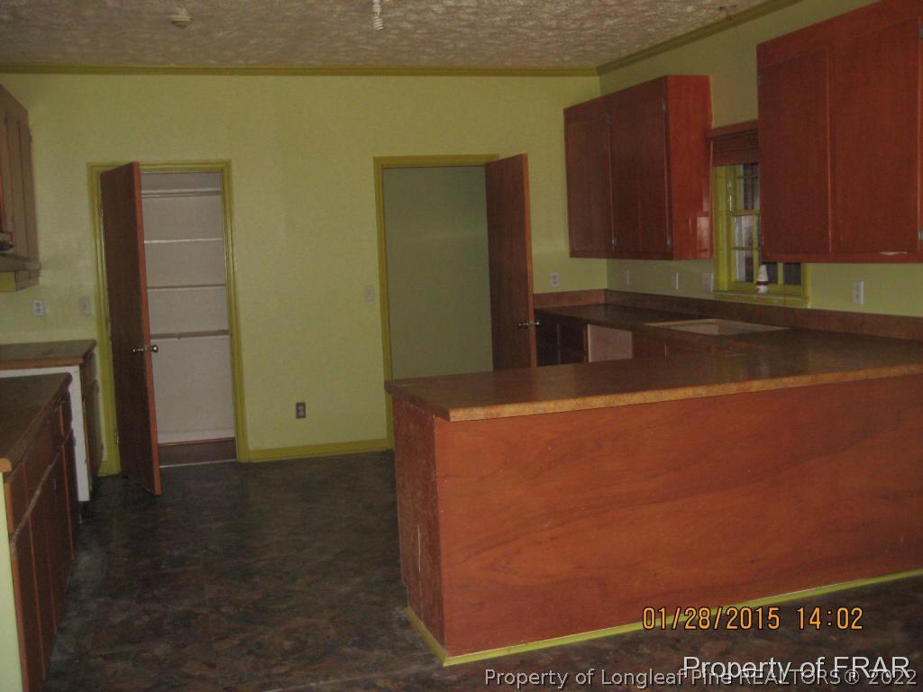 6904 Clinton Road Stedman, NC 28391 - Photo 3 of 6 a room with wooden floor and cabinets