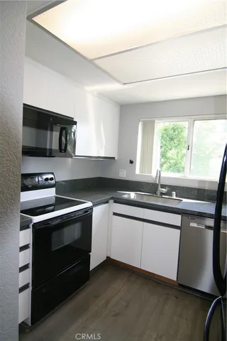 a kitchen with stainless steel appliances a stove sink and microwave