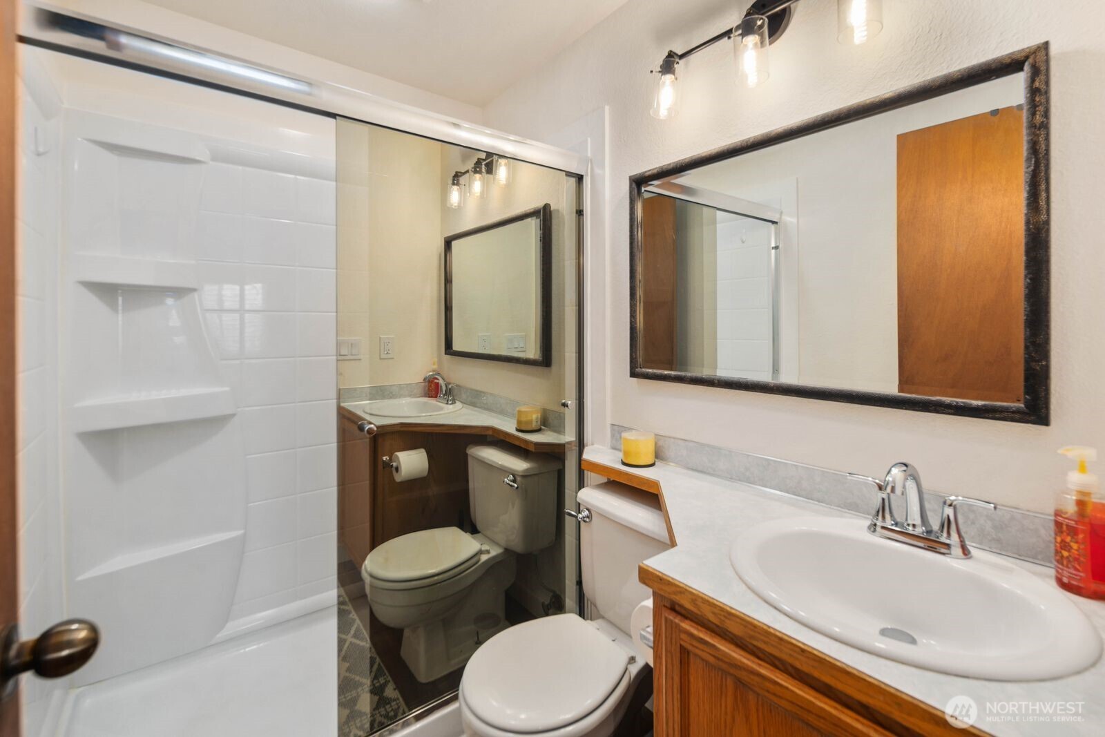 26121 193rd Place Southeast Covington, WA 98042 - Photo 12 of 21 a bathroom with a toilet sink a mirror and shower