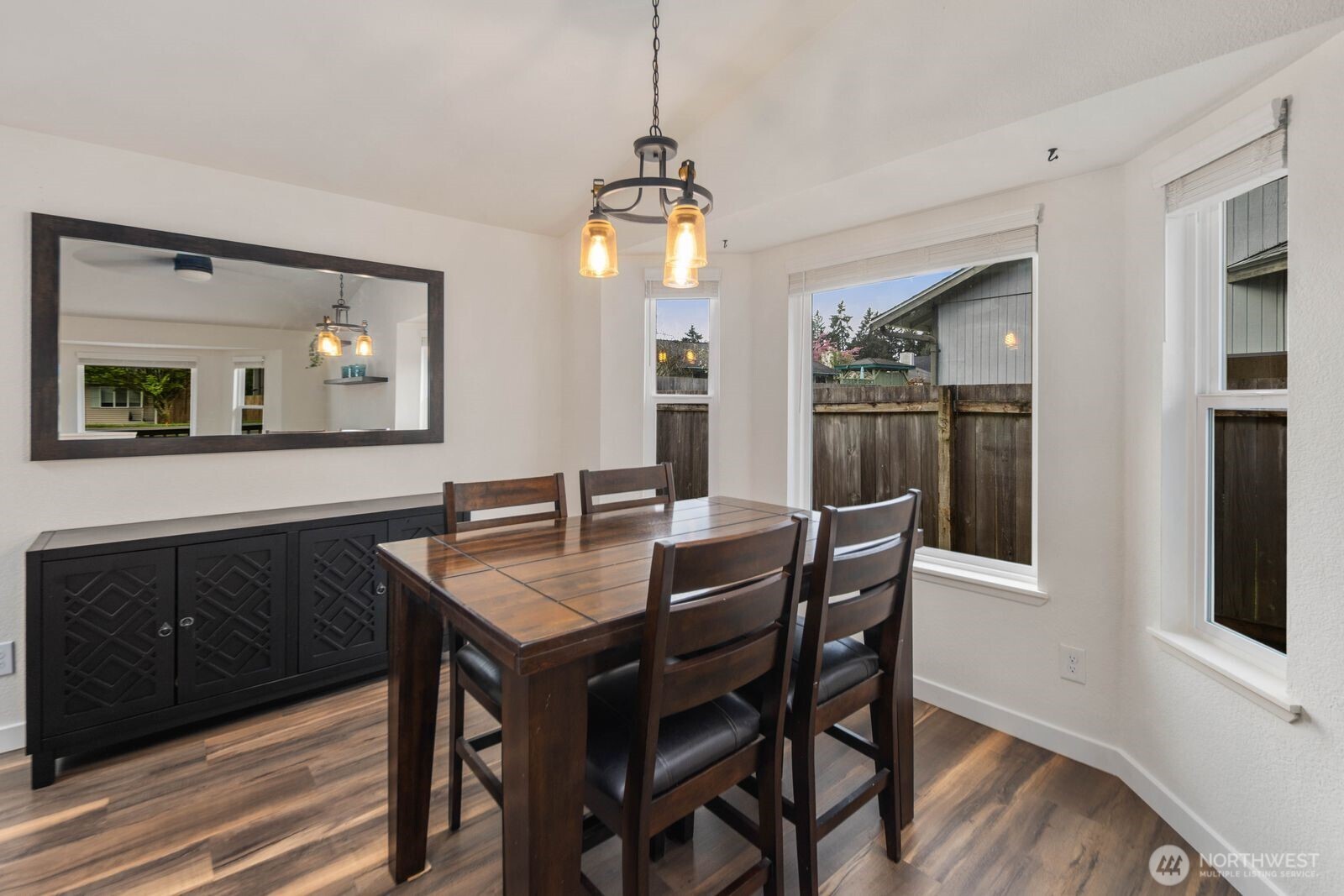 26121 193rd Place Southeast Covington, WA 98042 - Photo 6 of 21 a dining room with wooden floor a chandelier a wooden table and chairs