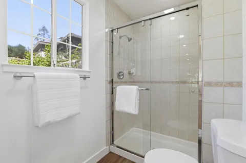 a bathroom with a shower a toilet and a window