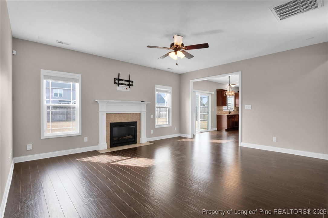 171 Tellmont Street Raeford, NC 28376 - Photo 11 of 46 an empty room with windows fireplace and wooden floor