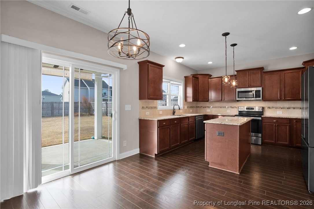 171 Tellmont Street Raeford, NC 28376 - Photo 13 of 46 a kitchen with kitchen island granite countertop wooden floors granite counter tops and a view of living room