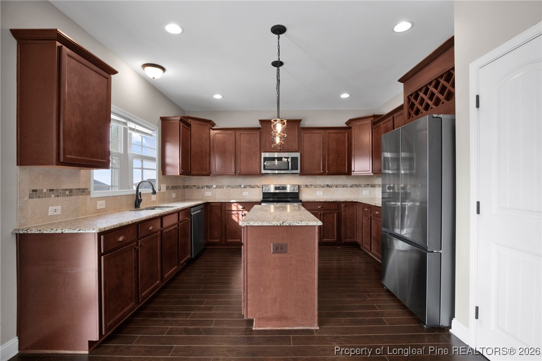 171 Tellmont Street Raeford, NC 28376 - Photo 14 of 46 a large kitchen with stainless steel appliances kitchen island granite countertop a stove a sink dishwasher a refrigerator and a oven with wooden floor