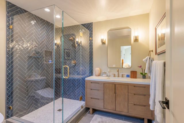 a bathroom with a double vanity sink mirror and shower