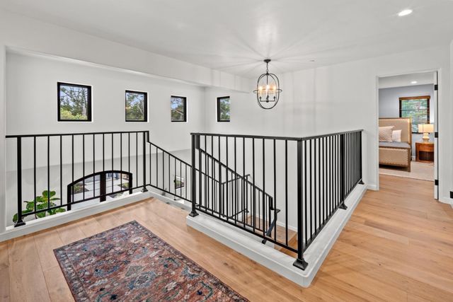 a view of a hallway with wooden floor and stairs