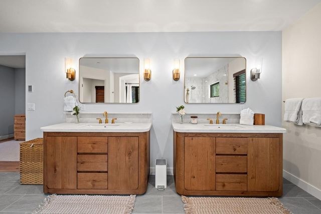 a bathroom with a double vanity sink and mirror