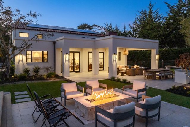 a view of a patio with couches table and chairs with garden view