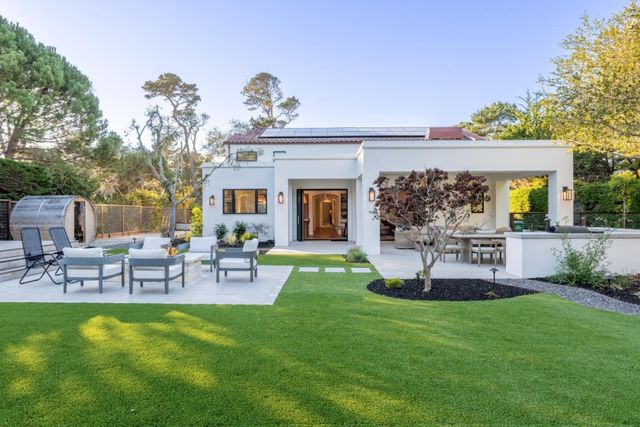 a view of a house with a backyard and a patio
