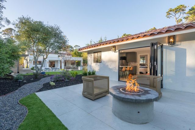 a view of a patio with couches table and chairs and potted plants
