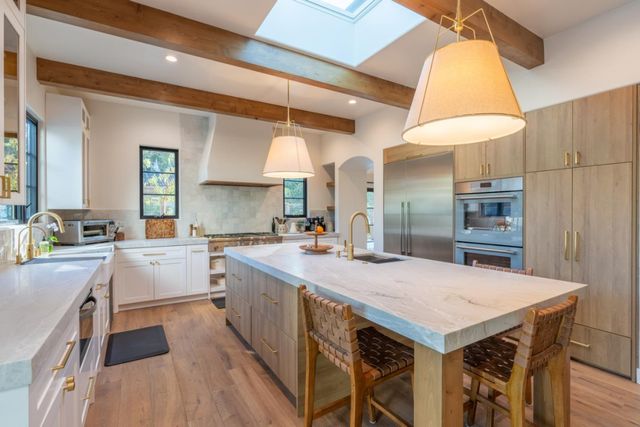 a kitchen with a table chairs sink and cabinets