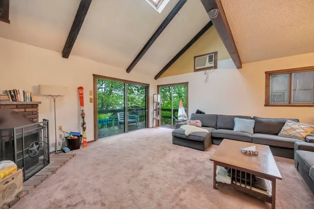a living room with furniture a fireplace and a large window