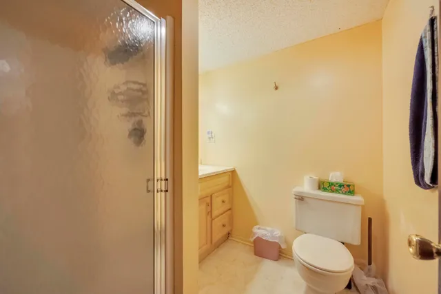 a white toilet sitting next to a bathroom sink and a shower
