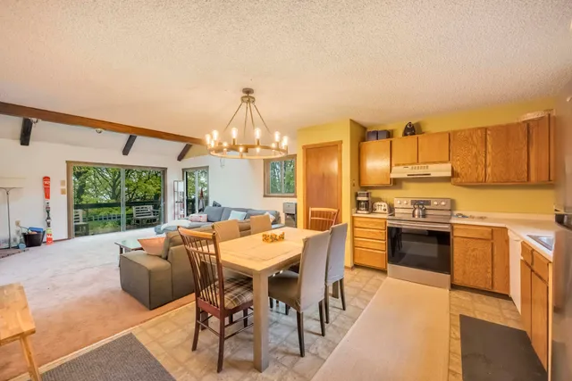 a view of a dining room with furniture a chandelier and wooden floor