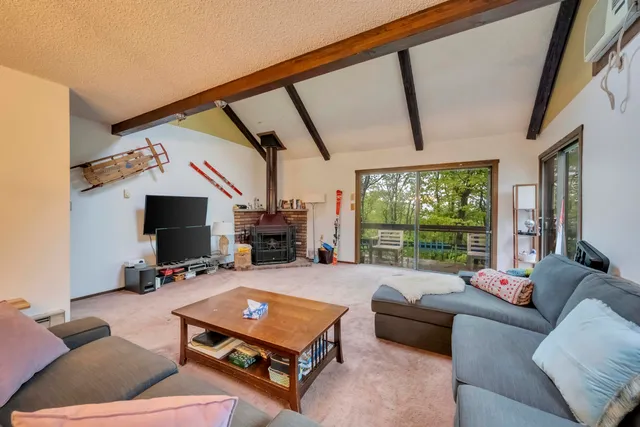 a living room with furniture a flat screen tv and a floor to ceiling window