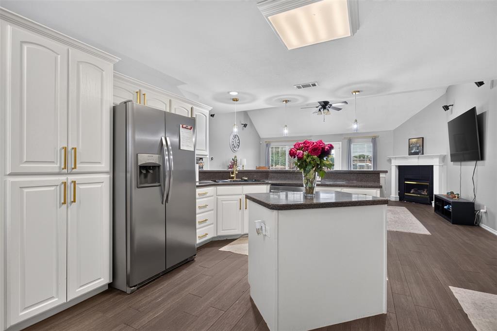 100 Radecke Road Krum, TX 76249 - Photo 15 of 29 Kitchen with white cabinetry, stainless steel refrigerator, dark countertops, and wood-finish flooring
