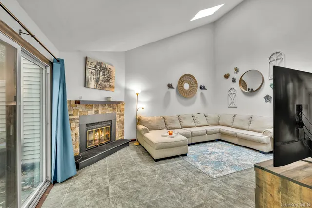 a living room with furniture a fireplace and a flat screen tv