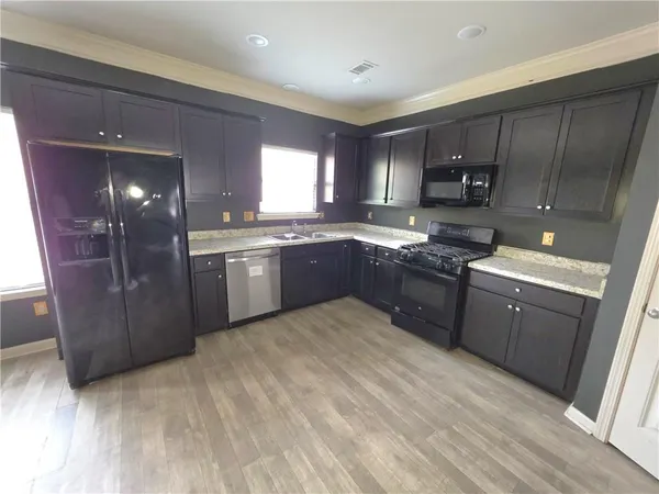 a kitchen with stainless steel appliances granite countertop a sink a stove a refrigerator and cabinets