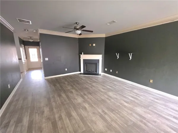 a view of an empty room with glass door and wooden floor