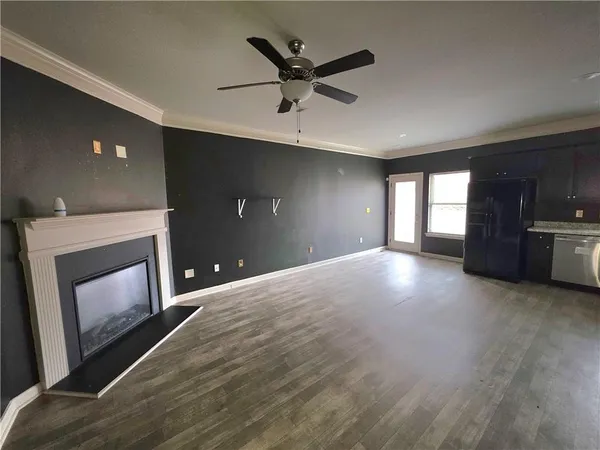 a view of an empty room with a fireplace and a window