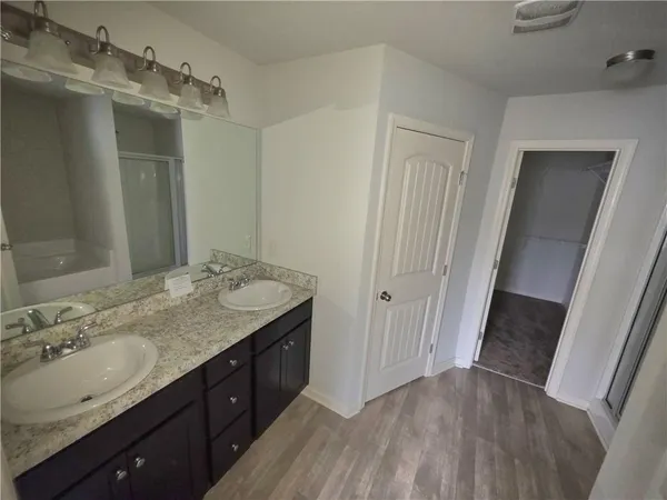 a bathroom with a granite countertop sink toilet a mirror a vanity and shower