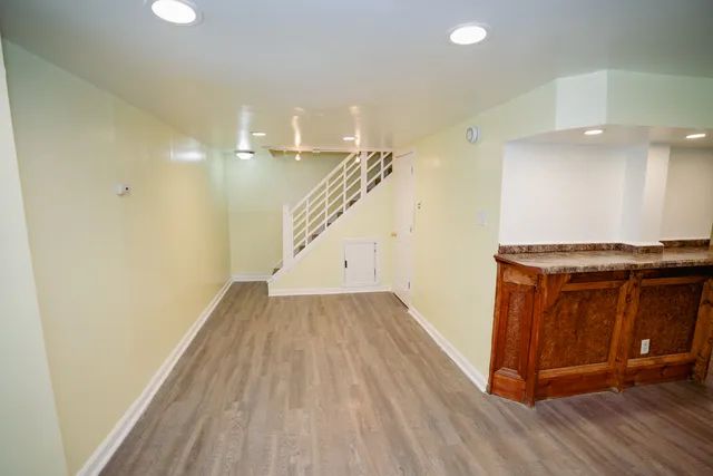 a view of an empty room with wooden floor and closet