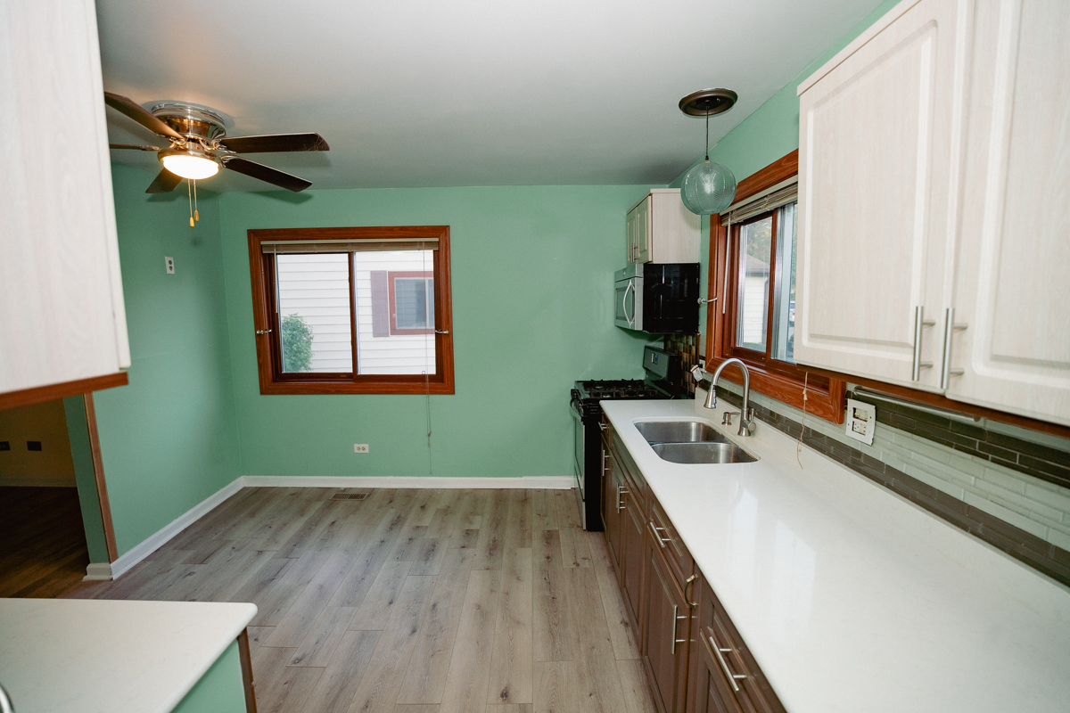 1221 Cedarwood Drive, Unit F Crest Hill, IL 60403 - Photo 5 of 35 a kitchen with a fridge and a wooden floor