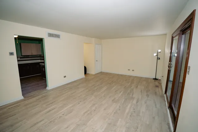 a view of empty room with wooden floor and electronic appliances