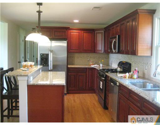 211 Lambertson Road Old Bridge, NJ 07747 - Photo 6 of 19 a kitchen with granite countertop a sink a counter top space appliances and cabinets