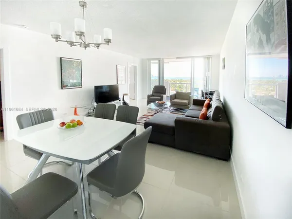 a living room with furniture a table and a large window