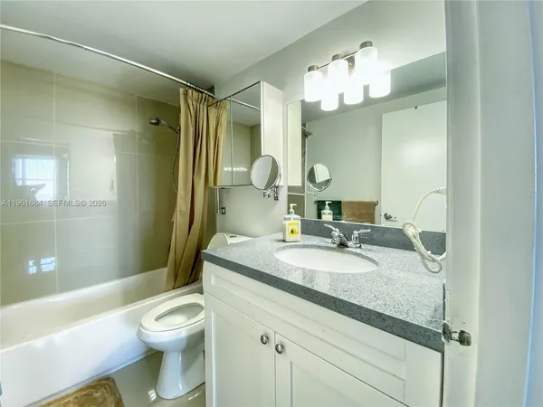 a bathroom with a granite countertop sink a toilet and a mirror