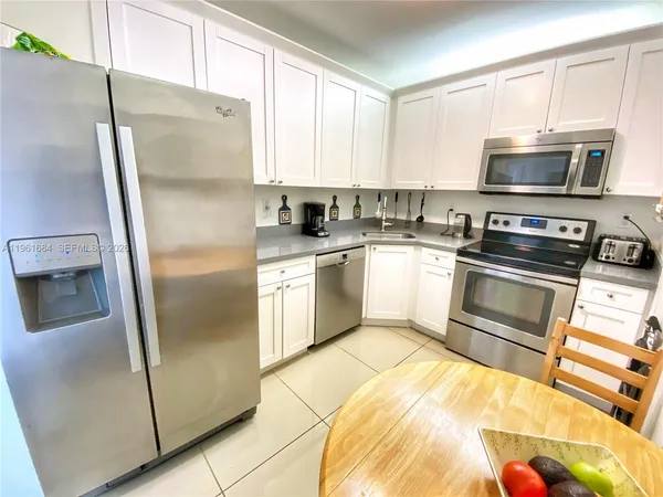 a kitchen with granite countertop a refrigerator stove and microwave