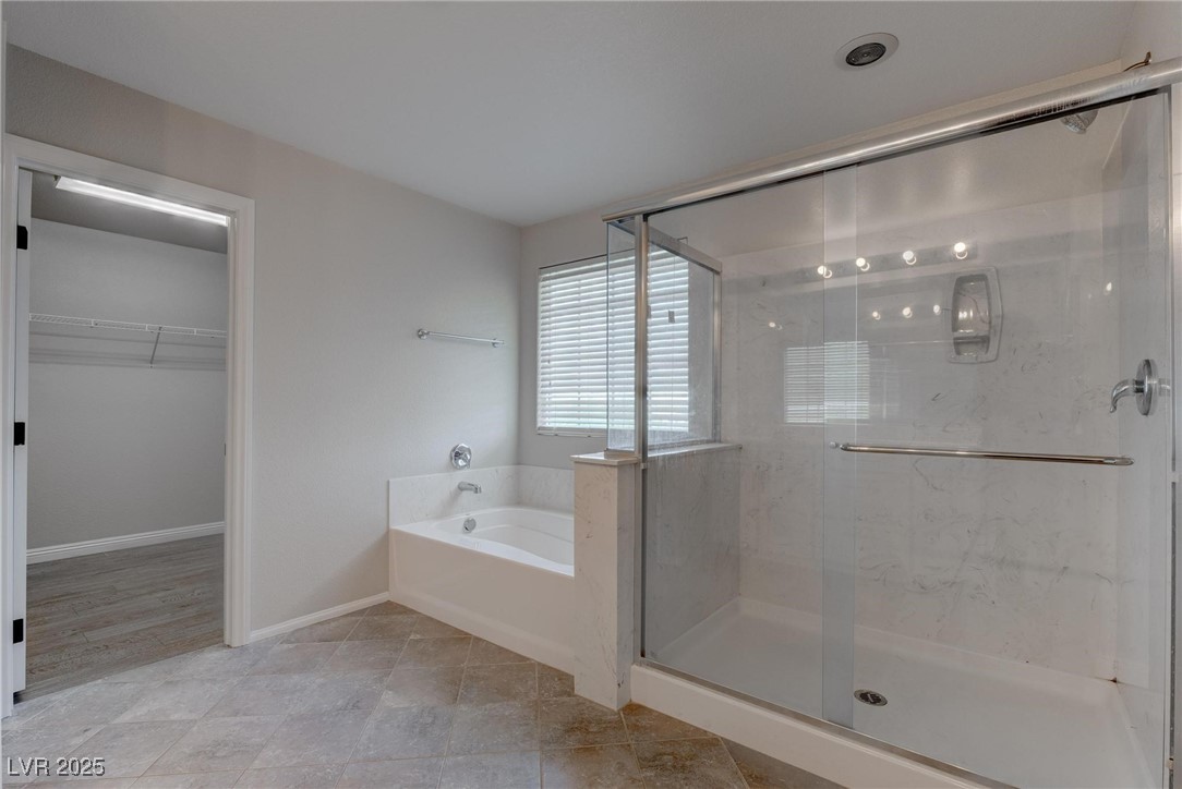 10273 Aragon Crown Road Las Vegas, NV 89135 - Photo 12 of 45 Bathroom with a spacious closet, a bath, a marble finish shower, and light tile patterned floors
