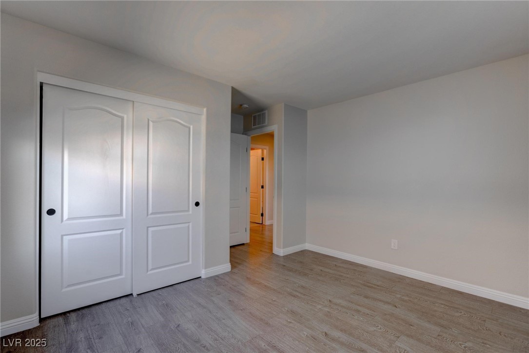 10273 Aragon Crown Road Las Vegas, NV 89135 - Photo 17 of 45 Unfurnished bedroom with light wood-style floors and a closet