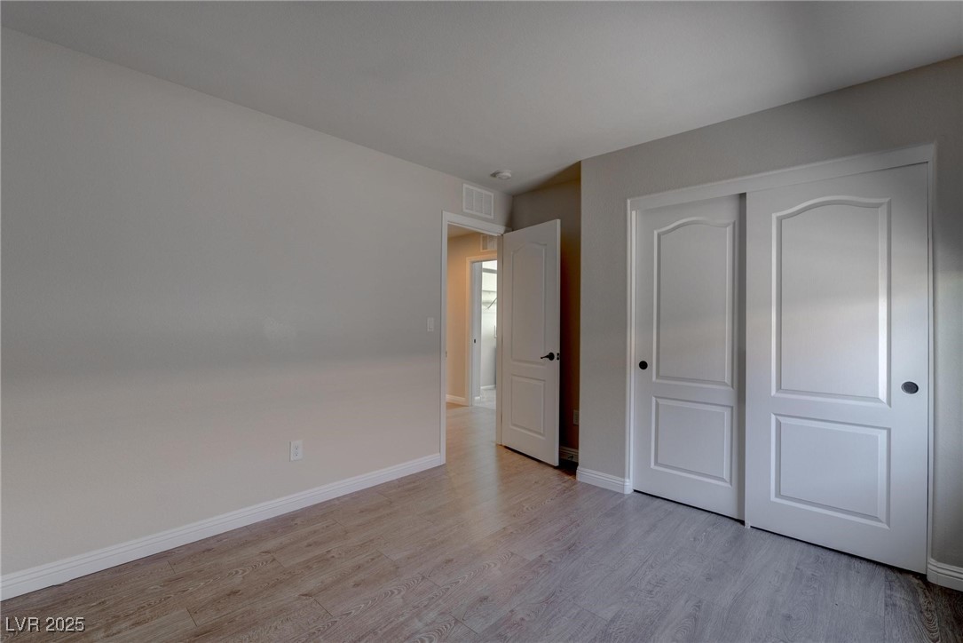 10273 Aragon Crown Road Las Vegas, NV 89135 - Photo 19 of 45 Unfurnished bedroom featuring light wood-type flooring and a closet