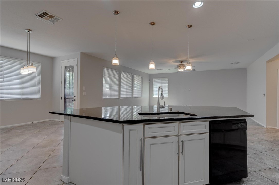 10273 Aragon Crown Road Las Vegas, NV 89135 - Photo 30 of 45 Kitchen featuring white cabinetry, light tile patterned floors, black dishwasher, an island with sink, and pendant lighting