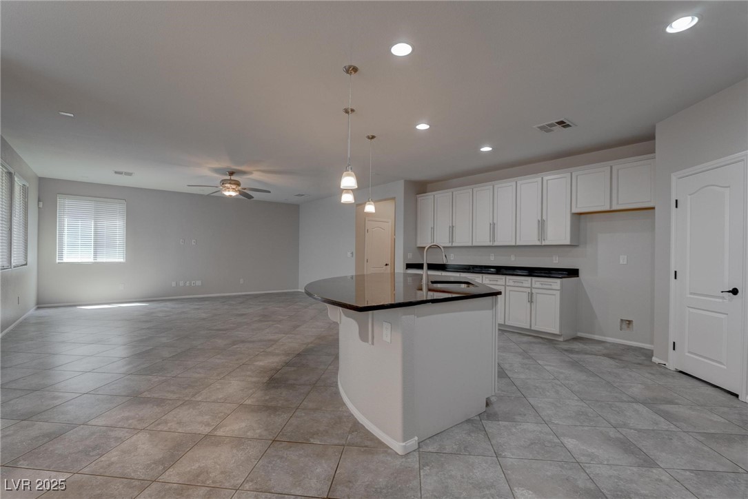 10273 Aragon Crown Road Las Vegas, NV 89135 - Photo 32 of 45 Kitchen with white cabinetry, hanging light fixtures, an island with sink, recessed lighting, and ceiling fan