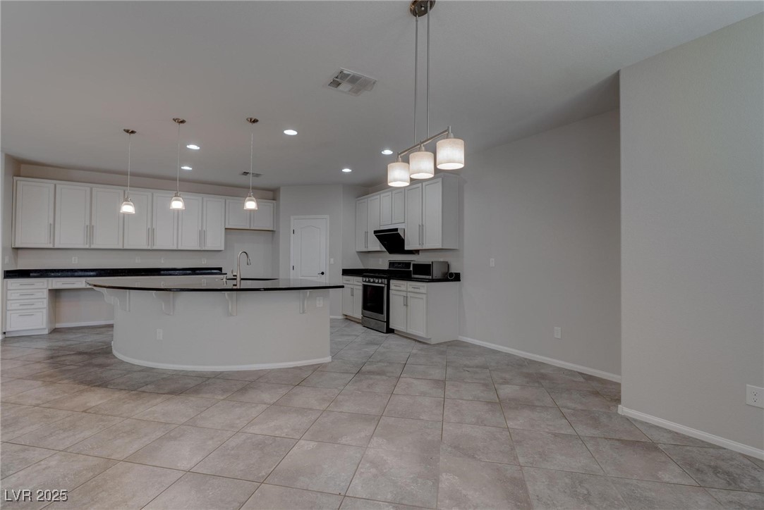 10273 Aragon Crown Road Las Vegas, NV 89135 - Photo 34 of 45 Kitchen with stainless steel appliances, hanging light fixtures, white cabinets, an island with sink, and recessed lighting