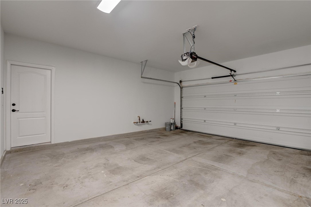 10273 Aragon Crown Road Las Vegas, NV 89135 - Photo 35 of 45 Garage featuring a garage door opener and baseboards