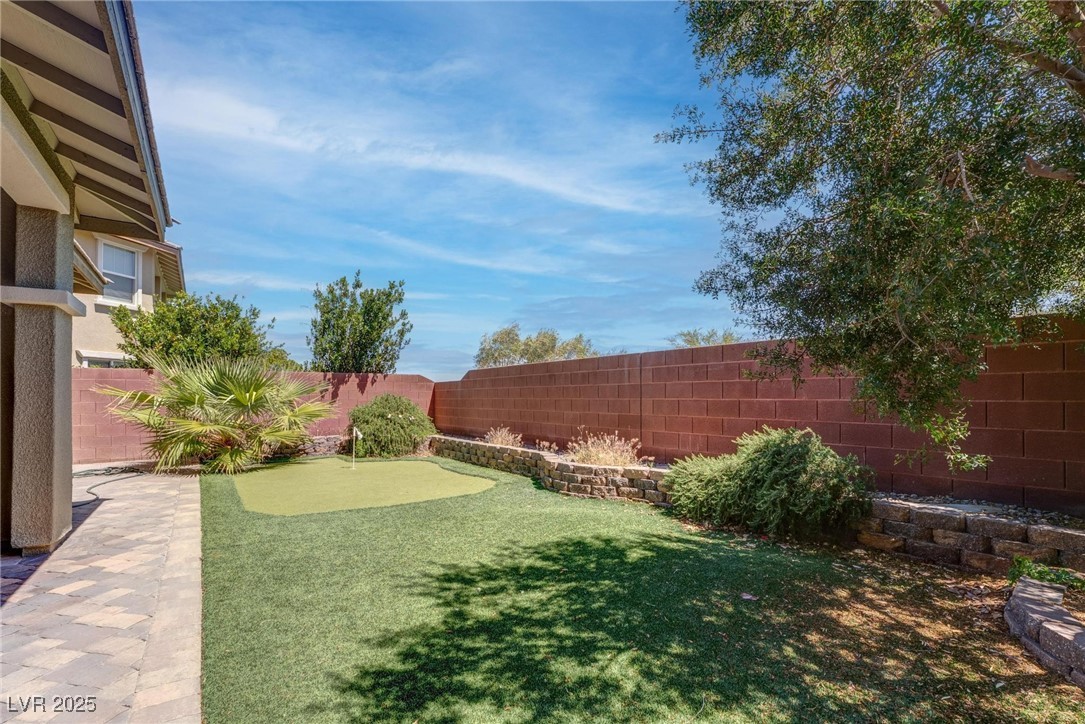 10273 Aragon Crown Road Las Vegas, NV 89135 - Photo 39 of 45 Fenced backyard featuring an area to practice putting and a patio