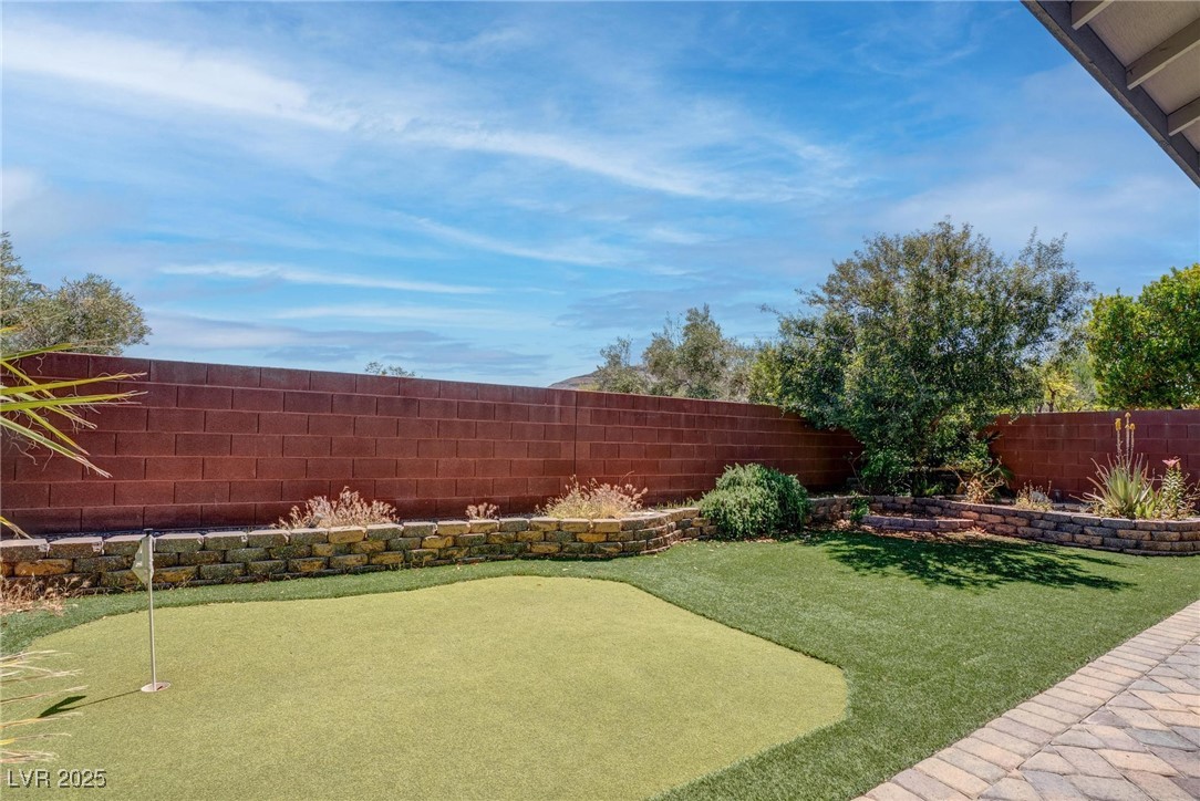 10273 Aragon Crown Road Las Vegas, NV 89135 - Photo 40 of 45 Fenced backyard featuring an area to practice putting and a patio