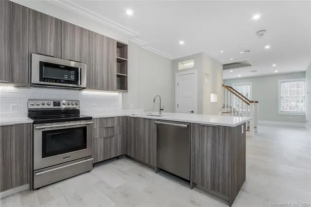 a kitchen with stainless steel appliances granite countertop a stove a microwave and a sink