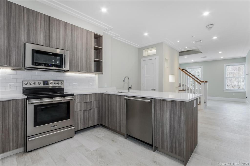 a kitchen with stainless steel appliances granite countertop a stove a microwave and a sink