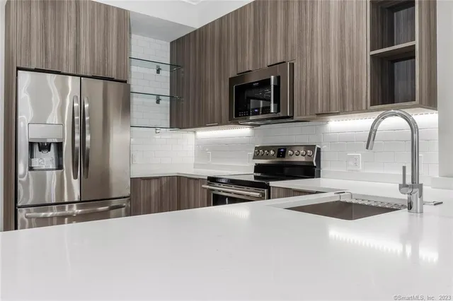 a kitchen with granite countertop a refrigerator and a sink